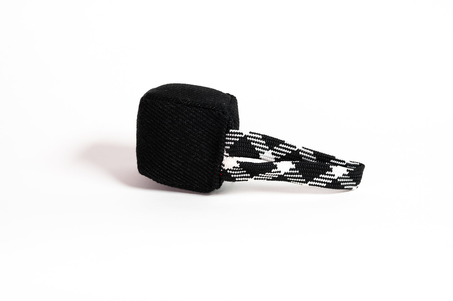 Black cube-shaped toy with black and white patterned strap