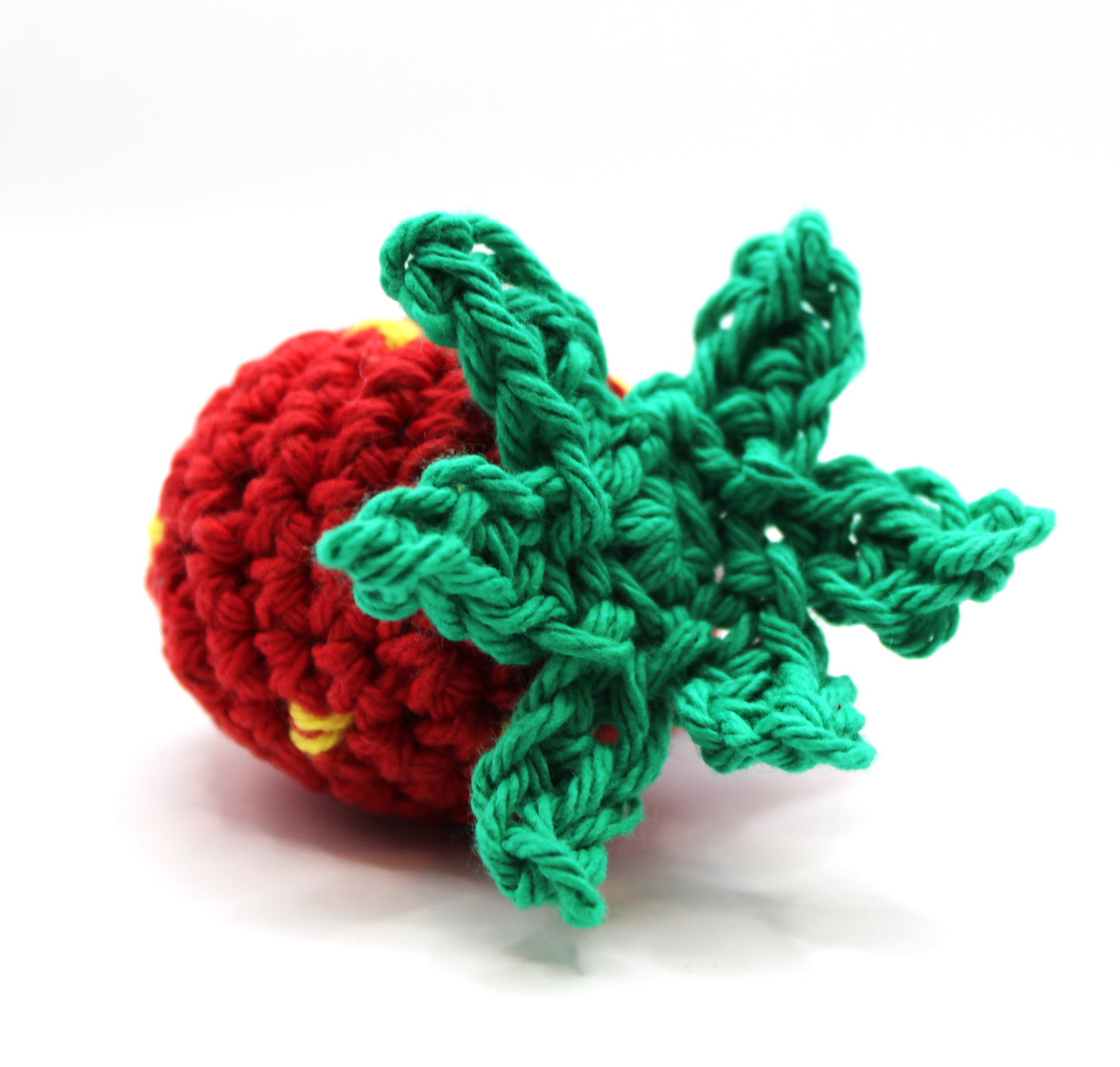 Crocheted red strawberry with green leaves