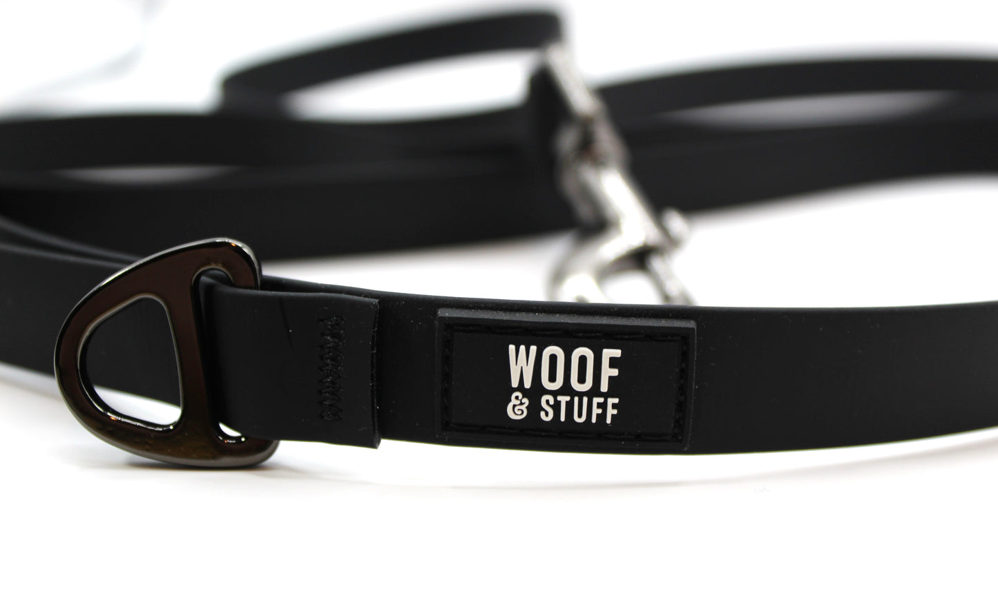 Close-up of a black dog leash with 'Woof & Stuff' label