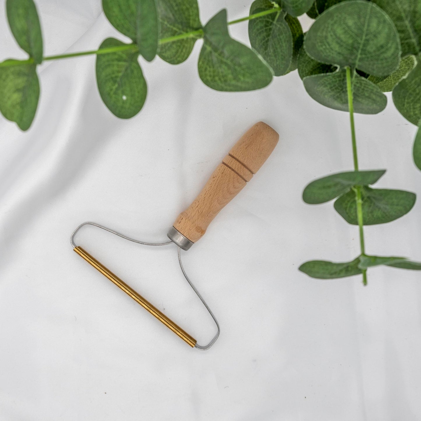 Metal and wood tool used to remove pet hair